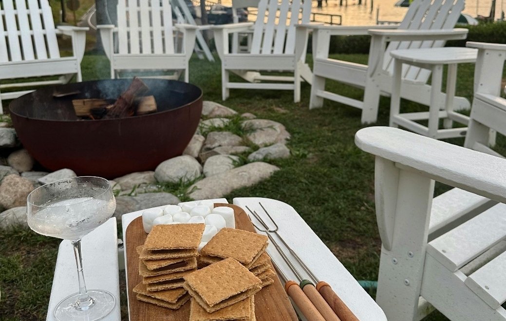 Marshmallow and wine next to a fire pit in a yard