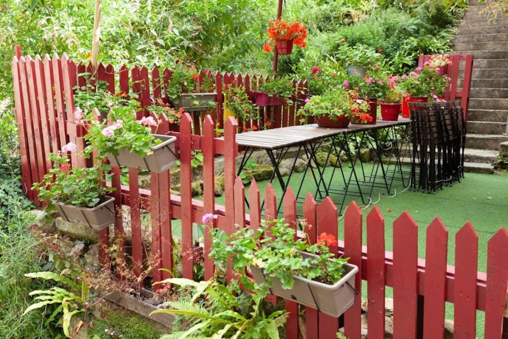 A fence, flowers, and synthetic grass on a terrace