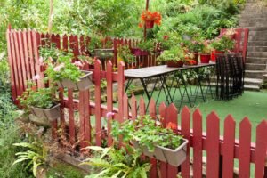 A fence, flowers, and synthetic grass on a terrace