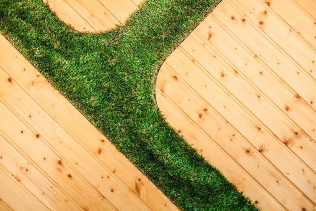 Wooden planks with artificial grass edging in backyard