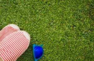 Artificial turf with scattered shoes and sunglasses