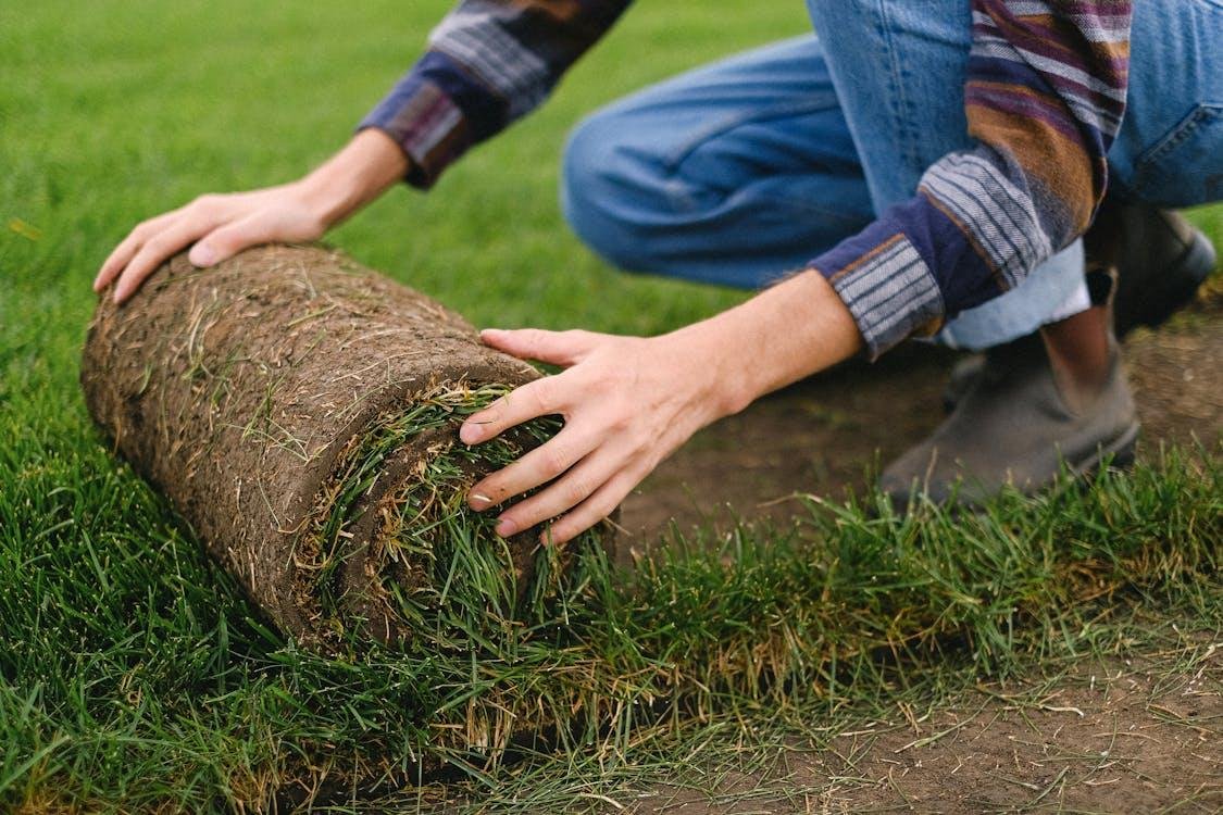 a person installing artificial grass in a backyard