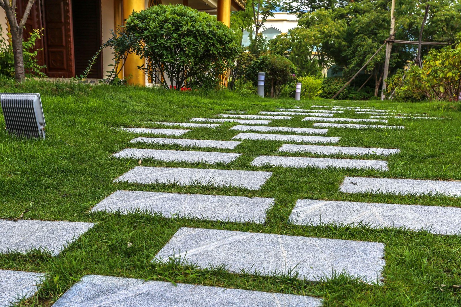 a pathway built on artificial grass in the backyard of a house