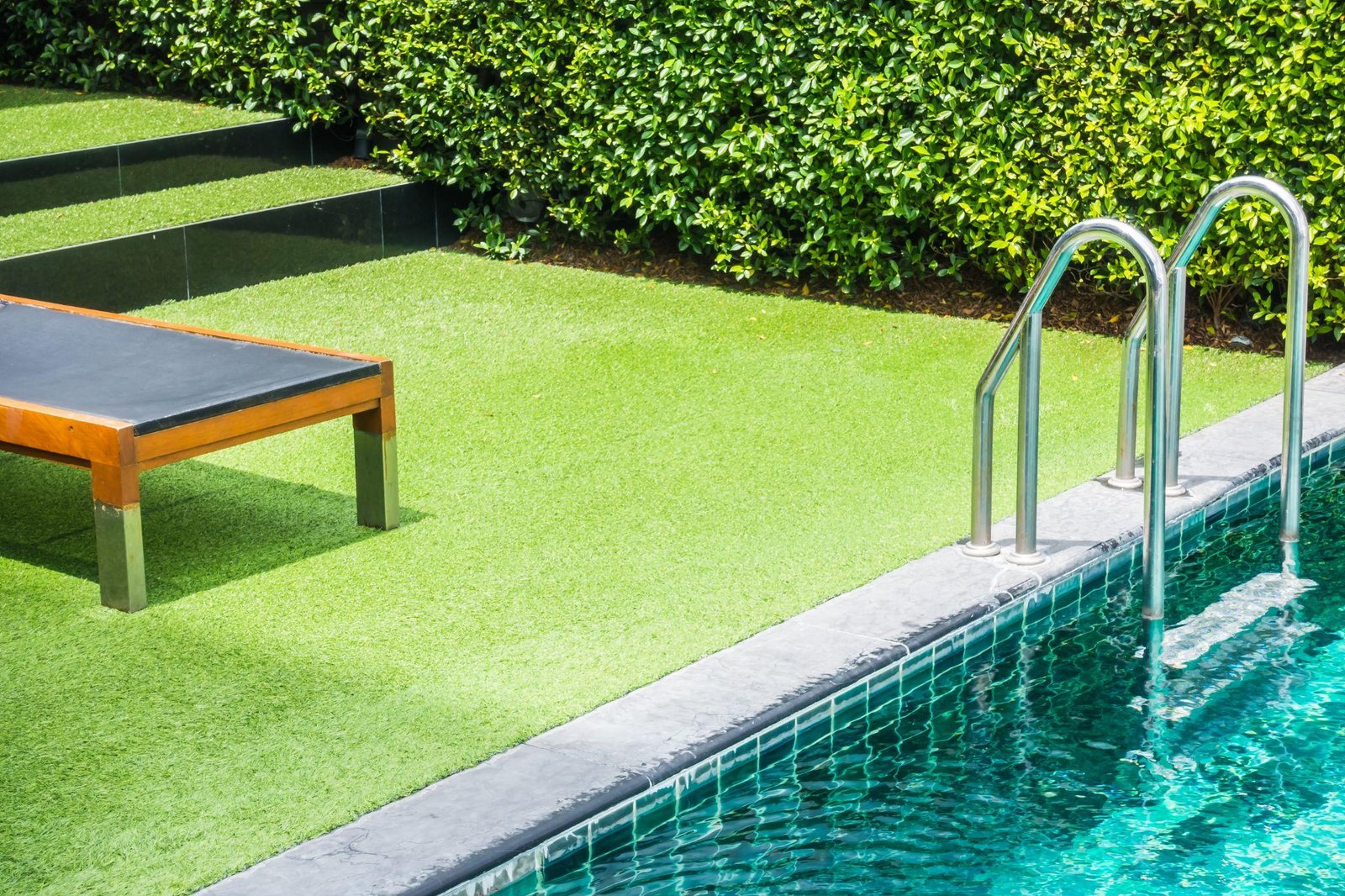 an artificial turf installed in the backyard connected to a pool