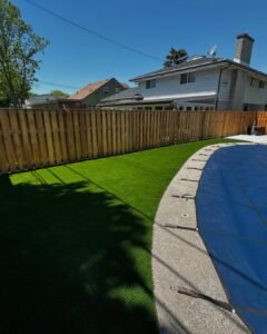 Artificial grass next to a brown fence