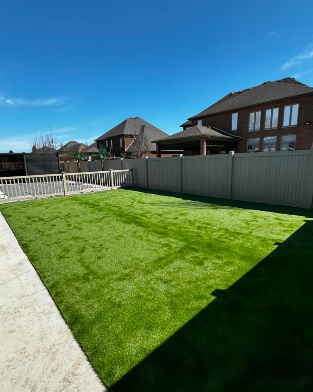 A large patch of artificial turf next to a fence