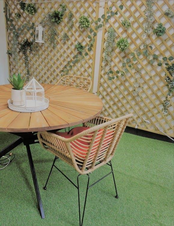 An image of a table and a chair on fake grass