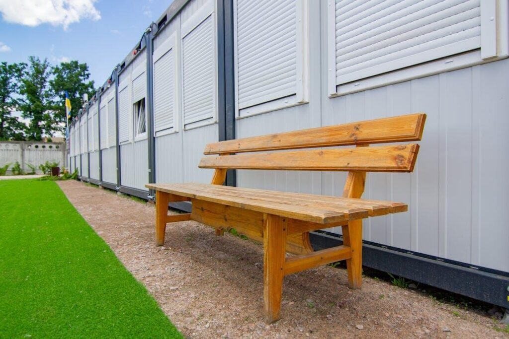 An image of a wooden bench near artificial grass