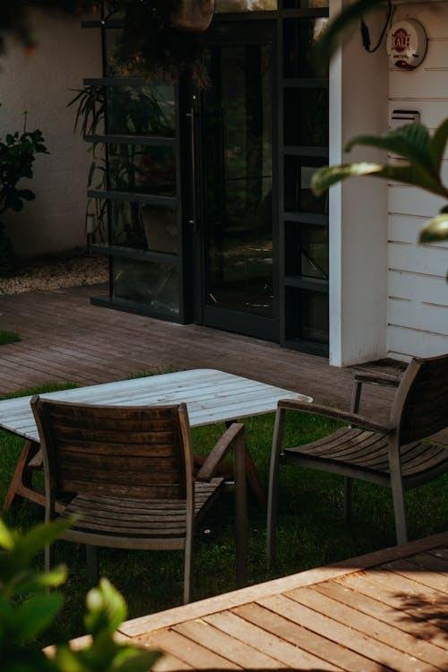 Outdoor chairs placed on artificial grass in a modern backyard seating area