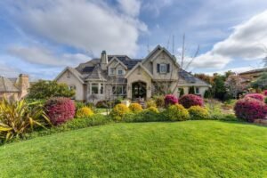 a house with different types of plants and flowers in the front yard