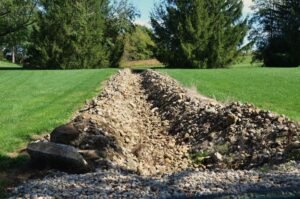 a trench dug up in a backyard